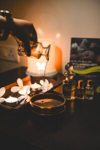 A tranquil scene of aromatherapy with pouring oil, candles, and a soothing atmosphere.
